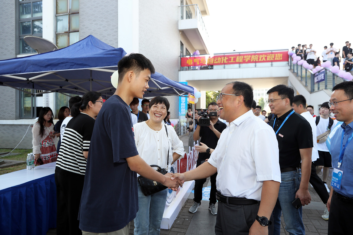 202309101694335322162159.jpg 王培君书记在电子信息新生报到处3与新生交流.JPG