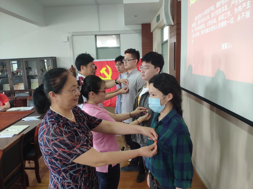 202005281590671362684414.jpg 4.为毕业生党员佩戴党徽.jpg