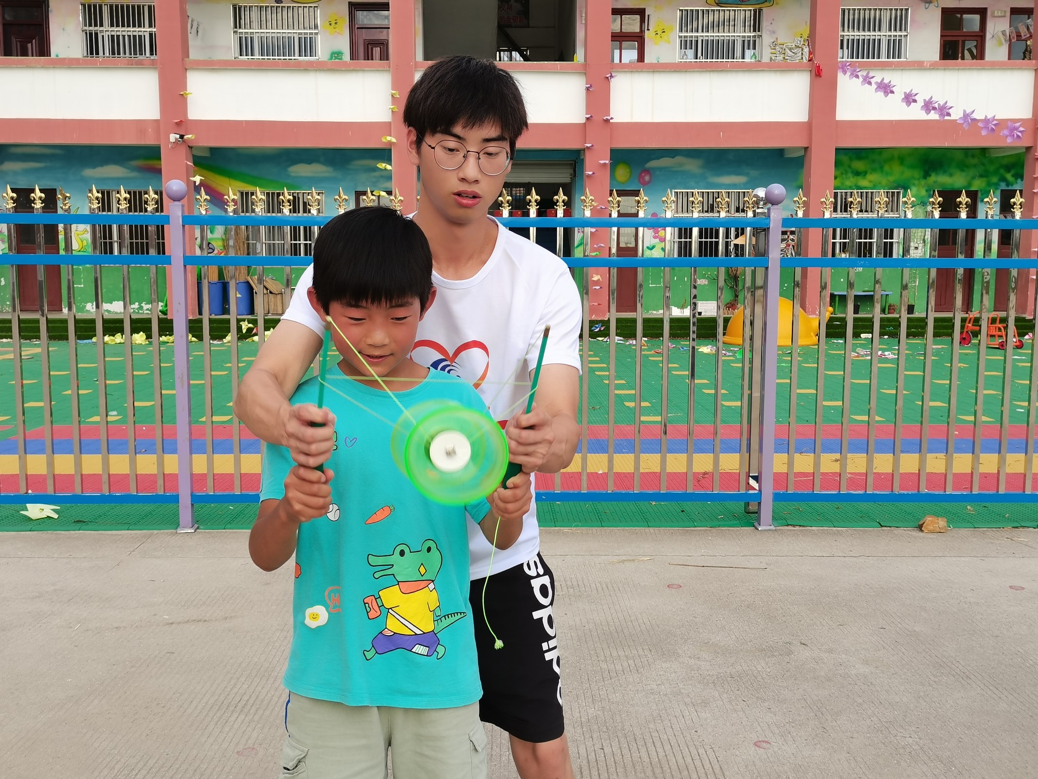 202107271627369842905653.jpg 材料工程学院爱心“1+1”七彩假期支教团在徐州市邢楼銮墩村向日葵读书站点志愿者教孩子空竹(1).jpg