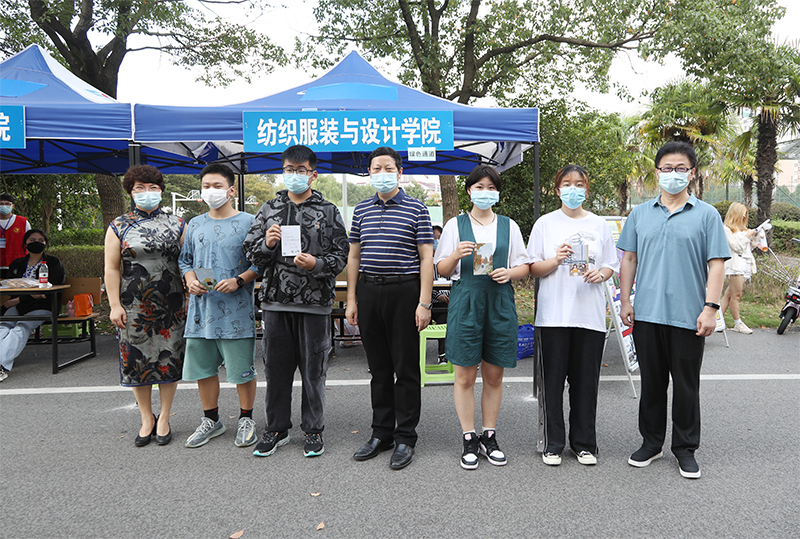 202110101633841819337417.jpg 5-1校领导给纺织与服装设计学院学生签名并合影.jpg